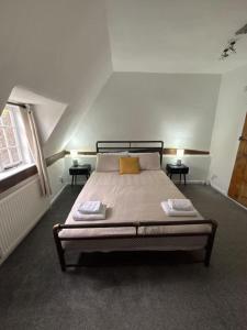 une chambre avec un grand lit avec deux tables de nuit dans l'établissement Countryside Cottage in Bulmer- Sleeps 6 7, à Sudbury