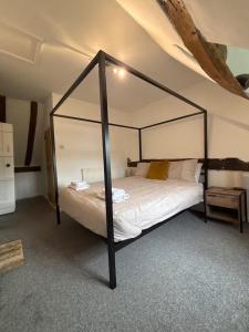 - une chambre avec un lit à baldaquin noir dans l'établissement Countryside Cottage in Bulmer- Sleeps 6 7, à Sudbury