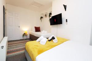 スウォンジーにあるContractor Base - 3 Beds - City Access - WiFiのタオルが敷かれたベッドが2つある寝室