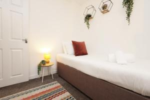 スウォンジーにあるContractor Base - 3 Beds - City Access - WiFiの白いベッドルーム(ベッド1台、テーブル付)