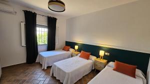 ein Hotelzimmer mit zwei Betten und einem Fenster in der Unterkunft Casa Rural The Hope in La Puebla de Cazalla + 29 Fotos