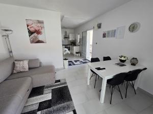 a living room with a couch and a table with chairs at Apartment Benda in Pag