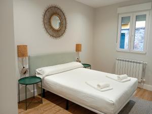 1 Schlafzimmer mit 2 Betten und einem Wandspiegel in der Unterkunft Apartamentos Marina Mar Vilagarcía 3000 in Villajuán