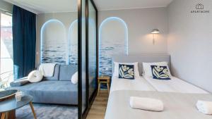 a hotel room with a bed and a couch at Portovo Residence managed by Apartmore in Gdańsk