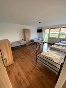 a room with beds and a table in it at Noclegi Rychwał in Rychwał