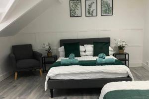 a bedroom with a large bed and a chair at Comfortable and Modern 2-Bedroom Flat in Bridgend in Bridgend +3 photos