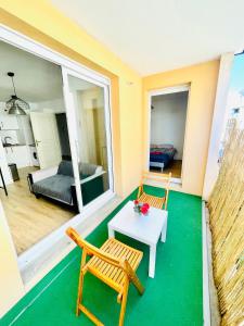 una camera con due sedie e un tavolo e una camera da letto di Appartement avec place de parking et piscine a Villefranche-sur-Saône
