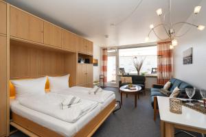 ヴェスターラントにあるStrandstraßeの大きなベッドとリビングルームのある寝室