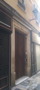 un accès à un bâtiment avec deux portes brunes dans l'établissement Ático centro "El diván azul", à Malaga