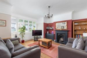 a living room with a couch and a fireplace at Bright & Spacious 3bedroom Home in Brighton & Hove