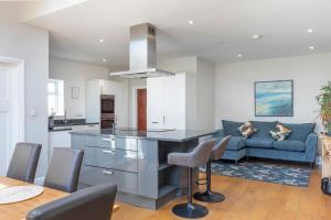 a kitchen and living room with a blue couch at Bright & Spacious 3bedroom Home in Brighton & Hove