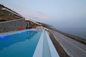 a swimming pool with a view of the ocean at Katerina's Residences in Vatera
