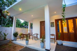 a porch of a house with chairs and plants at Mishu House in Ahangama