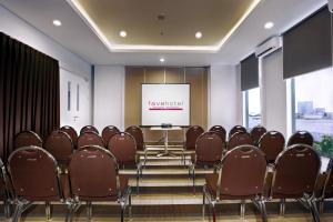 a conference room with chairs and a screen at favehotel Rungkut Surabaya in Surabaya