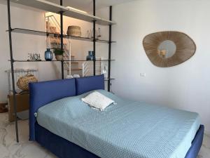 a bedroom with a blue bed and a mirror at Golfo Ameno Apartment in Portovenere