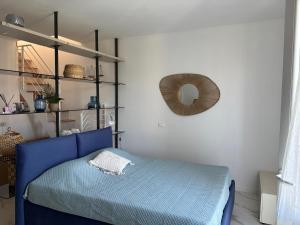 a bedroom with a blue bed and a mirror at Golfo Ameno Apartment in Portovenere