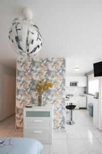 biały pokój z kuchnią i stołem z kwiatami w obiekcie Le Jasseron - Appartement cosy avec garage quartier PartDieu w mieście Lyon