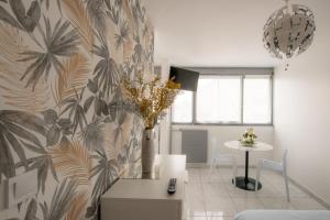 salon z wazą kwiatów na ścianie w obiekcie Le Jasseron - Appartement cosy avec garage quartier PartDieu w mieście Lyon