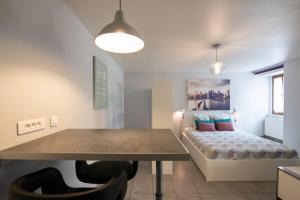 a dining room with a table and a bed at Le cocon des Monts d'Or in Saint-Germain-au-Mont-dʼOr