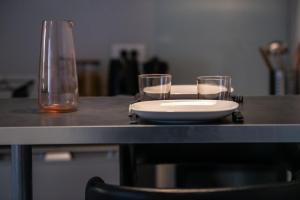 a table with a plate and two glasses on it at Le cocon des Monts d'Or in Saint-Germain-au-Mont-dʼOr