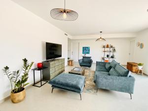 a living room with a couch and a tv at Villa chic & Zen - Workation - Plage à 10min in Vaux-sur-Mer