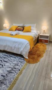 a bedroom with a large bed with yellow sheets and a rug at Exquisite 6 bedroom Villa in Nakuru in Nakuru