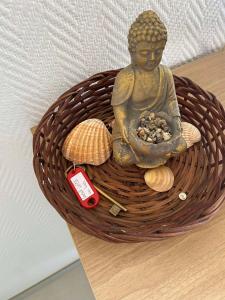 une statue d'un Bouddha assis dans un panier dans l'établissement Studio 212 lumineux à deux pas de l'océan, à Seignosse 19 autres photos