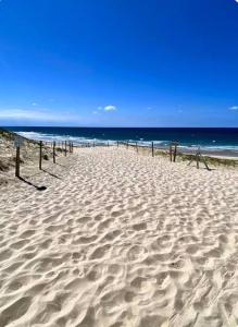 une plage de sable avec un pont en bois sur la plage dans l'établissement Studio 212 lumineux à deux pas de l'océan, à Seignosse