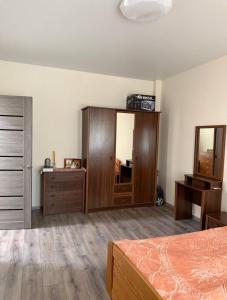a bedroom with a bed and a dresser and a mirror at Центр Благомед Парк з Кондиціонером in Luts'k