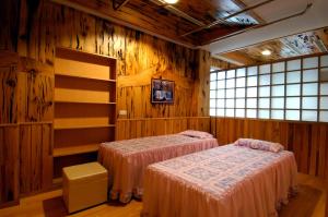 2 camas en una habitación con paredes de madera en Sun Moon Bed& Breakfast, en Wulai