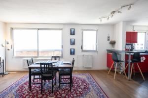 Una cocina y un comedor con mesa y sillas. en L'Alto - Bel appartement lumineux -Vue panoramique, en Gare des Brotteaux 20 fotos más