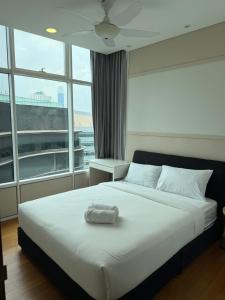 a bedroom with a white bed with a large window at vortex luxury apartment klcc in Kuala Lumpur