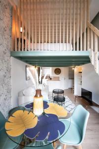 Una habitación con una mesa y sillas y una escalera. en Le Gary - Appartement atypique refait à neuf - A deux pas Parc Tête d'Or, en Gare des Brotteaux