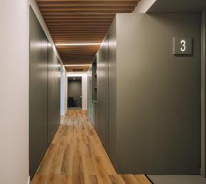 a hallway with metal doors and wooden floors at Alojamento Nave Ribeiro in Montelavar
