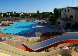 una gran piscina con gente. en Mobil Home Glycines 1, en Valras-Plage