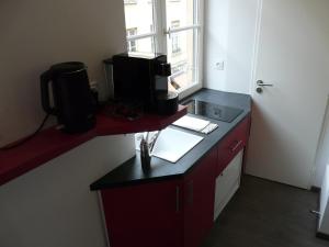 a kitchen with a red counter top and a window at Le 12 Pierres - Croix-Rousse - Cosy & Design in Lyon