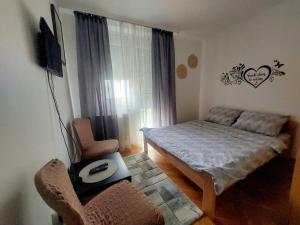 a small bedroom with a bed and a chair at Stan na dan Alexa sa free parkingom in Novi Sad