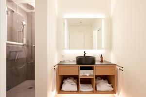 un baño con lavabo y espejo en Steinenschanze Charming City & Garden Hotel, en Basilea