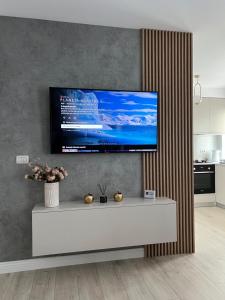a living room with a flat screen tv on a wall at City Nest Apartament in Rădăuţi