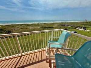 two chairs sitting on a balcony overlooking the beach at Luxurious 67 Direct Oceanfront at Spanish Main in Cocoa Beach
