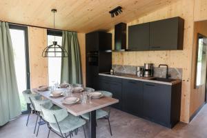 a kitchen with a wooden table with chairs and a counter at 't Groote Veen in Hoogersmilde