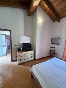 a bedroom with a bed and a flat screen tv at Emma Lake Apartment lago di Viverone in Viverone