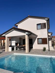 a house with a swimming pool in front of a house at Villa Navis in Kras +29 photos