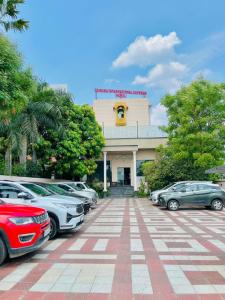 um estacionamento com carros estacionados em frente a um prédio em SAIBABA INTERNATIONAL SUPREME Hotel em Shirdi