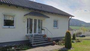 a white house with stairs in front of it at Ferienwohnung Am Lollbach in Bad Kissingen