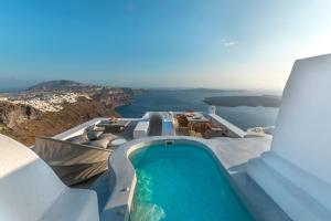 a swimming pool on a cliff next to the ocean at Pura Vida Villa in Imerovigli