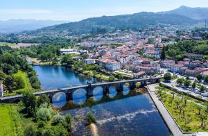 a bridge over a river with a city at PLACIDO RIVER HOUSE APARTAMENTO in Ponte da Barca