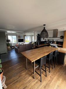 eine Küche und ein Wohnzimmer mit einem großen Holztisch in der Unterkunft Charmante Maison Néo-bretonne in Perros-Guirec