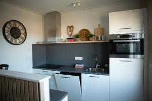 a kitchen with a sink and a stove top oven at Hello Zeeland - Appartement Weststraat 14 in Domburg