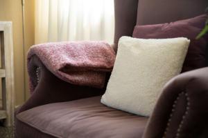 a couch with a blanket and a pillow on it at Hello Zeeland - Appartement Weststraat 14 in Domburg